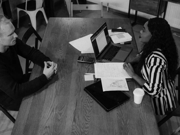 Colleagues discussing work at a table
