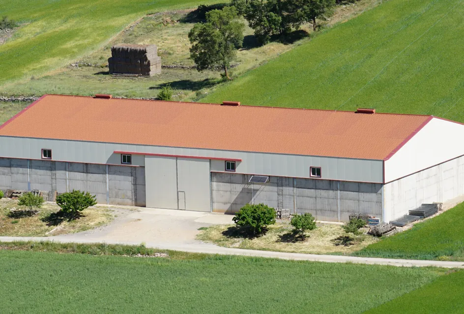 Overhead view of a large barn with a red roof