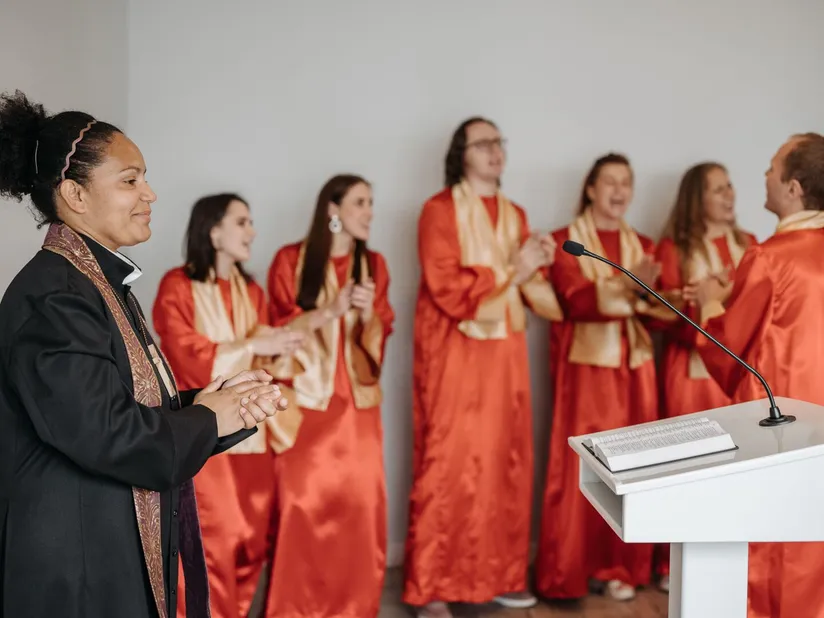 A choir in red robes singing joyfully during worship