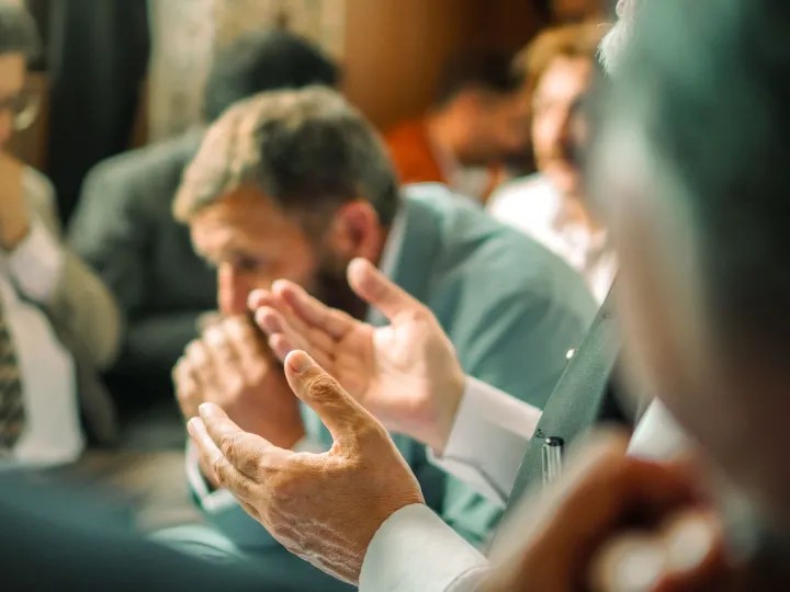 Friends praying together at a small group meeting