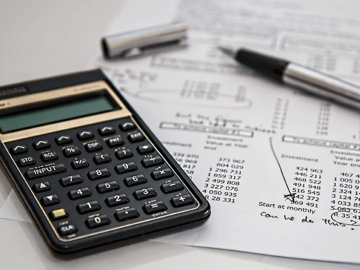 Calculator and silver pen on a printed financial statement