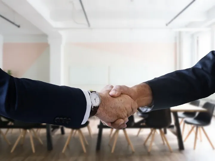 Recruitment consultant shaking hands with a candidate in a modern office