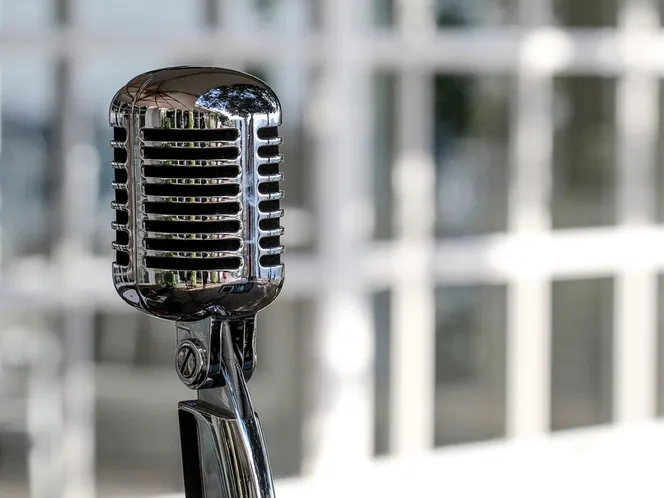 A vintage chrome microphone on a stand in a church hall