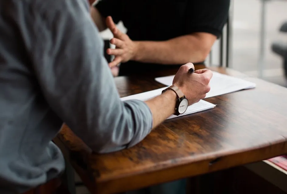 Colleagues discussing papers and taking notes around a table