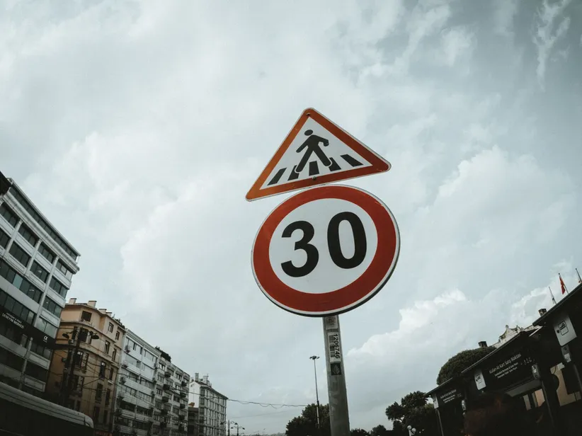 Low-angle view of pedestrian and speed limit