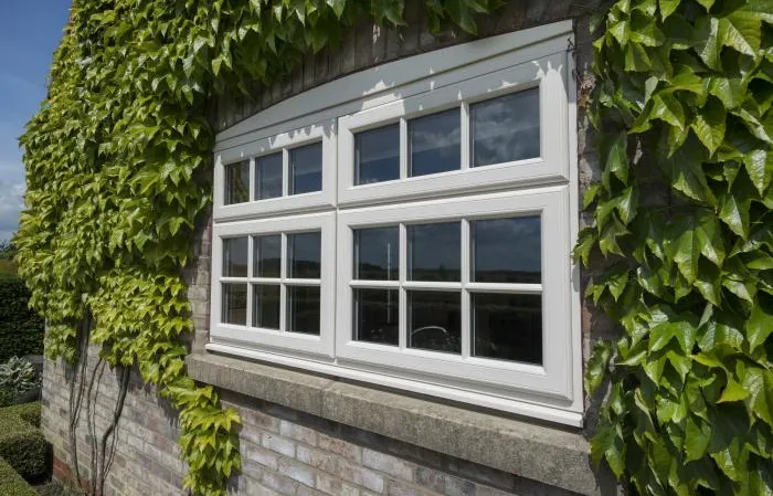 White uPVC window with ivy covered wall