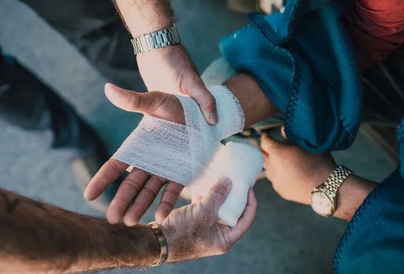 Person Applying Bandage on Another Person's Hand