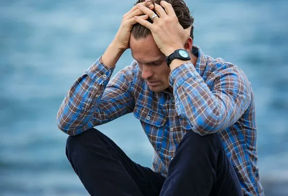 Man in Blue and Brown Plaid Dress Shirt Touching His Hair