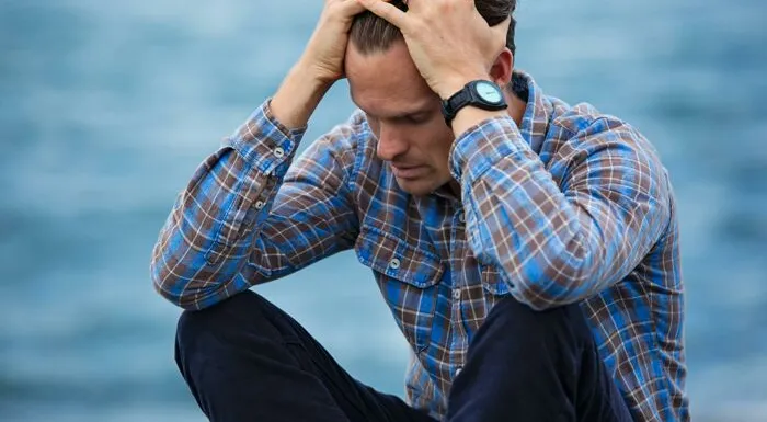 Man in Blue and Brown Plaid Dress Shirt Touching His Hair