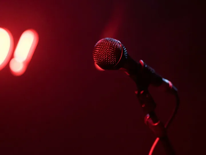 Microphone on stage with glowing red 'GO!' sign, perfect for nightlife themes.