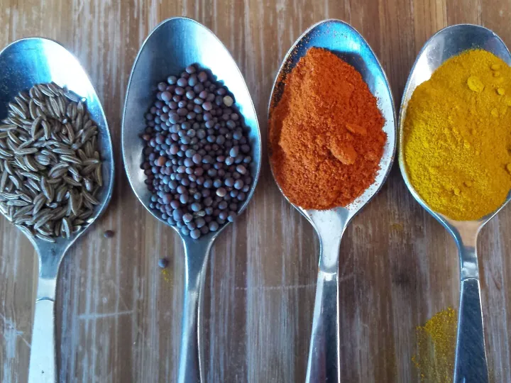 Four teaspoons of coloured condiments