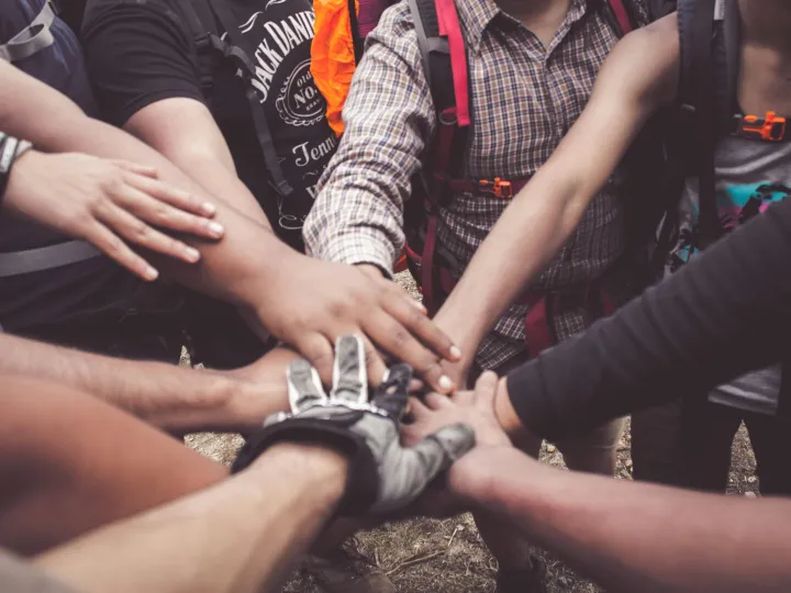 A group of diverse individuals join hands for