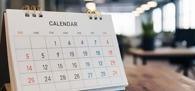 White paper desk calendar on wood table top with