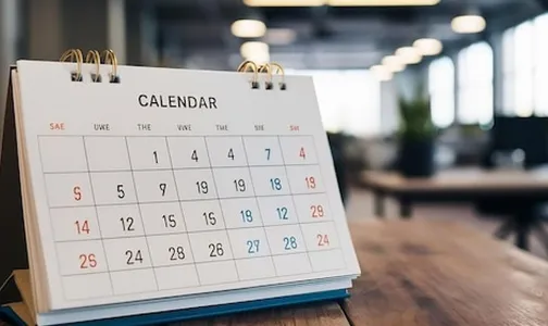 White paper desk calendar on wood table top with