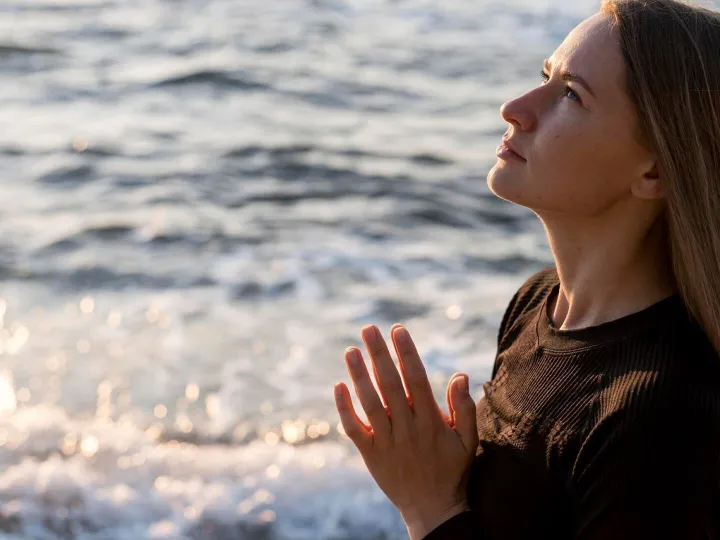 Sideways woman meditating on the beach