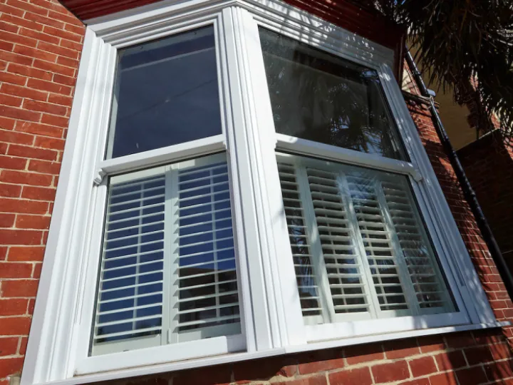 Sash window with blinds on red brick