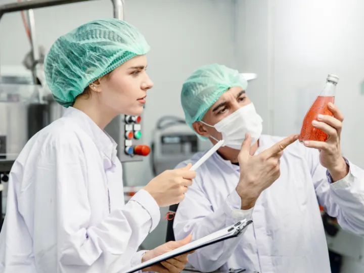 Quality control and food safety team inspection the product standard in the food and drink factory production line.