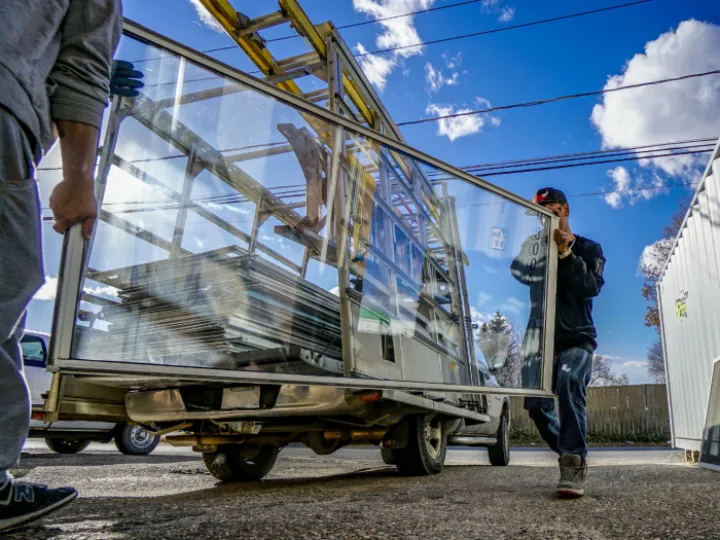 Workers carrying aluminium window