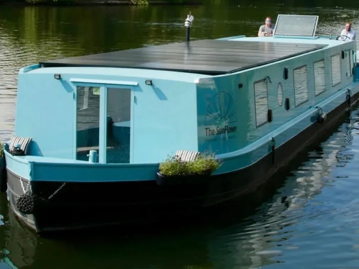 A blue solar powered river boat on the water