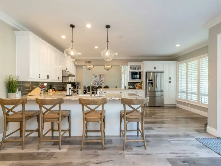 Bright and spacious kitchen interior featuring bar stools and modern design elements.