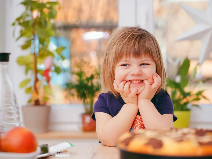 A happy young girl smiling indoors surrounded by