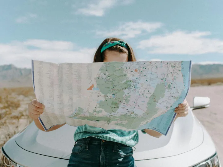 A woman holds a map while traveling through the