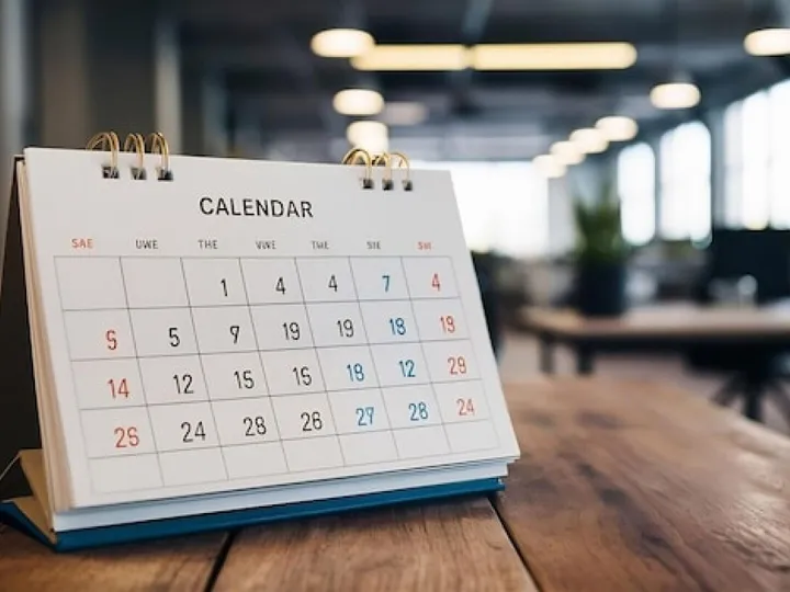 White paper desk calendar on wood table top with