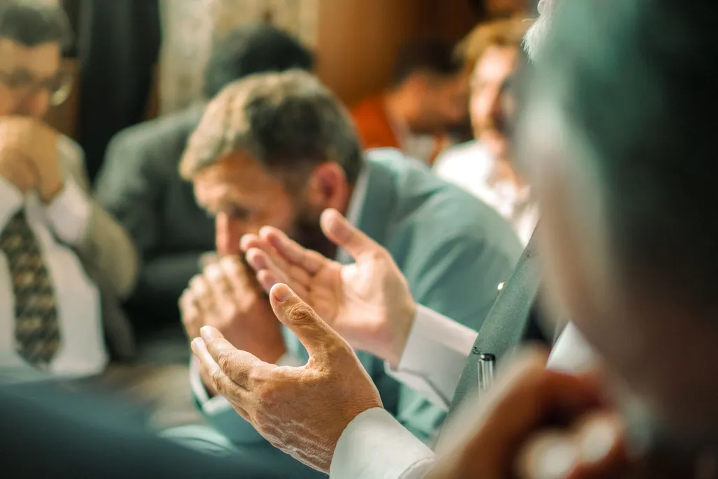 Friends praying together at a small group meeting