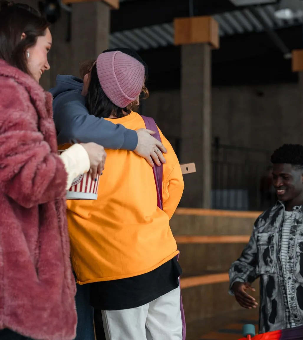 Friends greeting one another with a hug