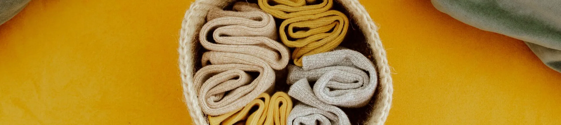 Neatly rolled socks in a woven basket