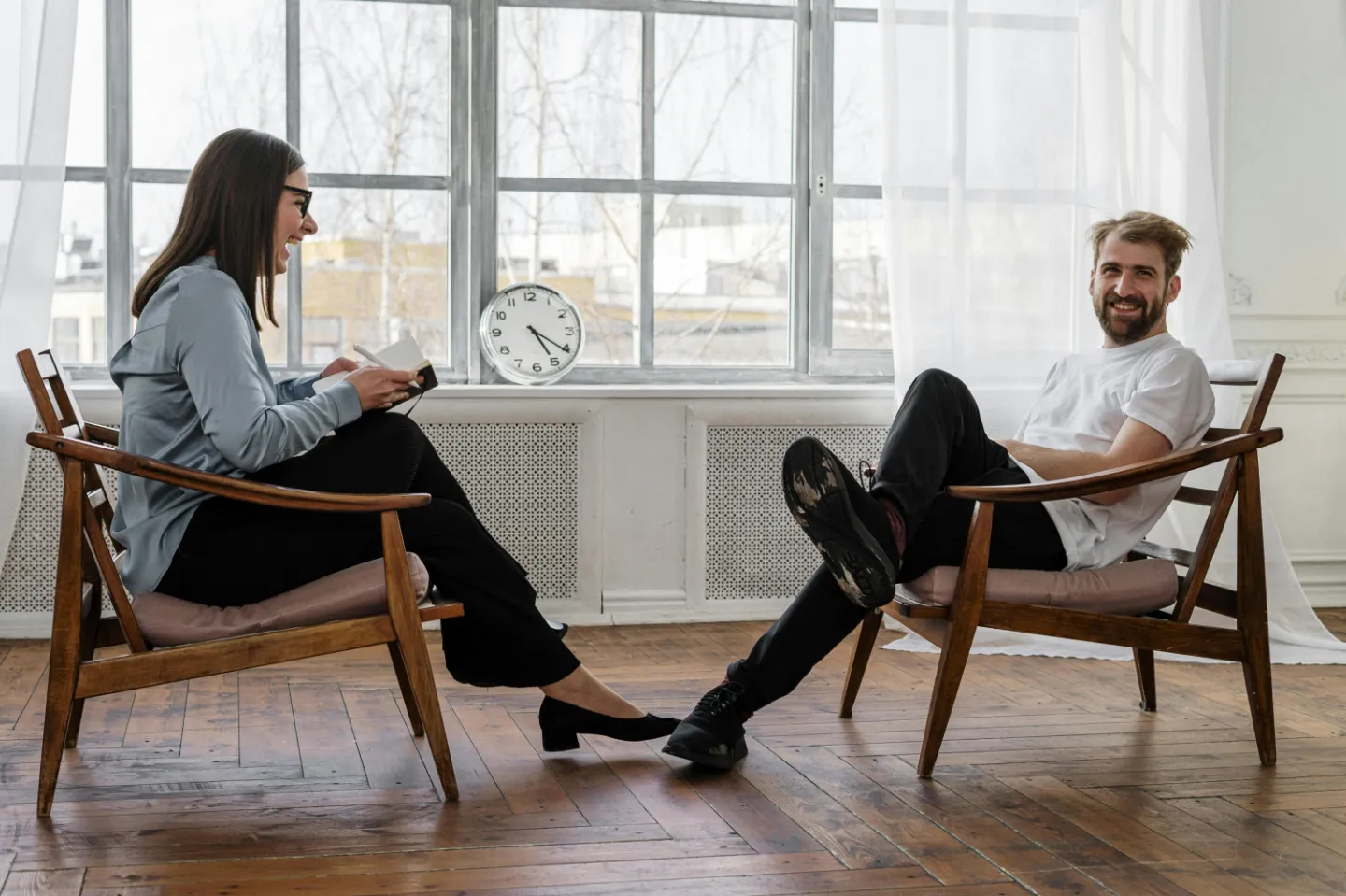 2 Women Sitting on Brown Wooden Chair