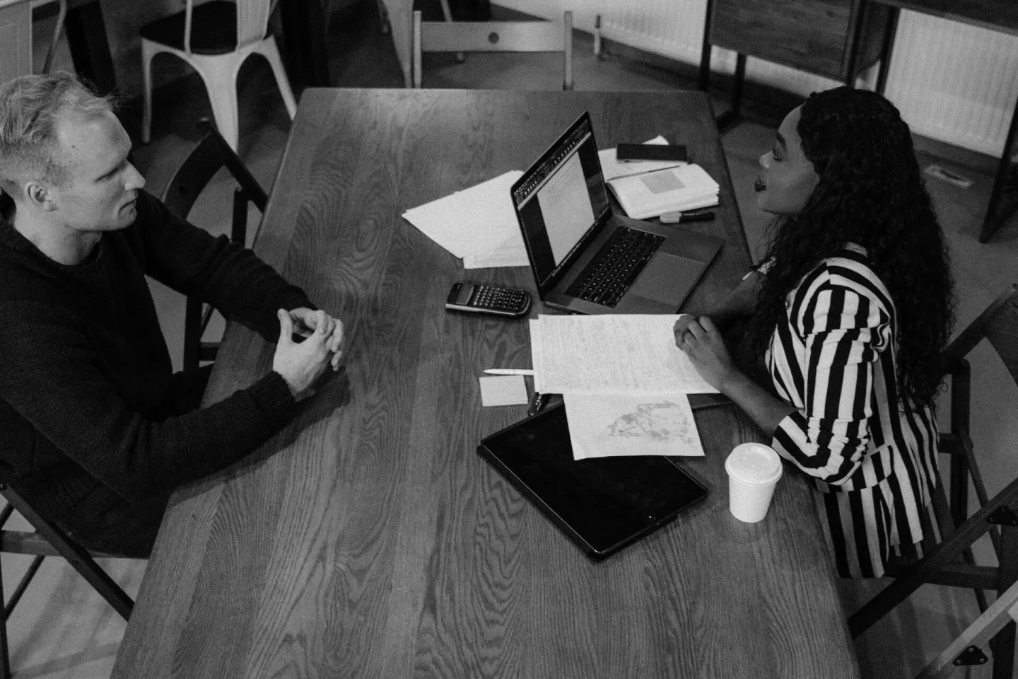A man and woman discussing work at a table with