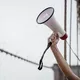 A hand holding a megaphone, symbolizing protest