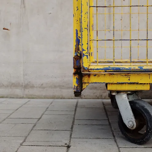 Detailed view of a rusty yellow industrial cart