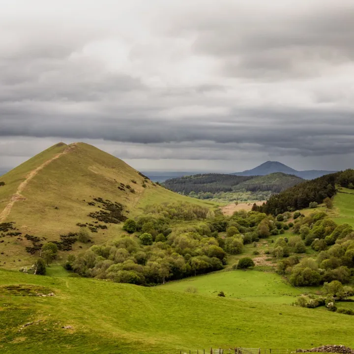 Capture of rolling hills under stormy skies in