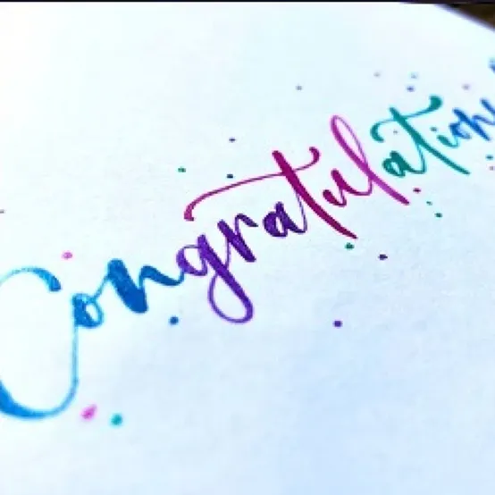 Congratulations in rainbow watercolour brush lettering on white card