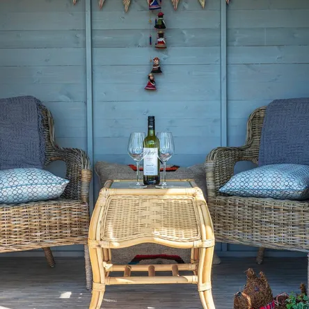 Inside the summerhouse with wine and wicker chairs