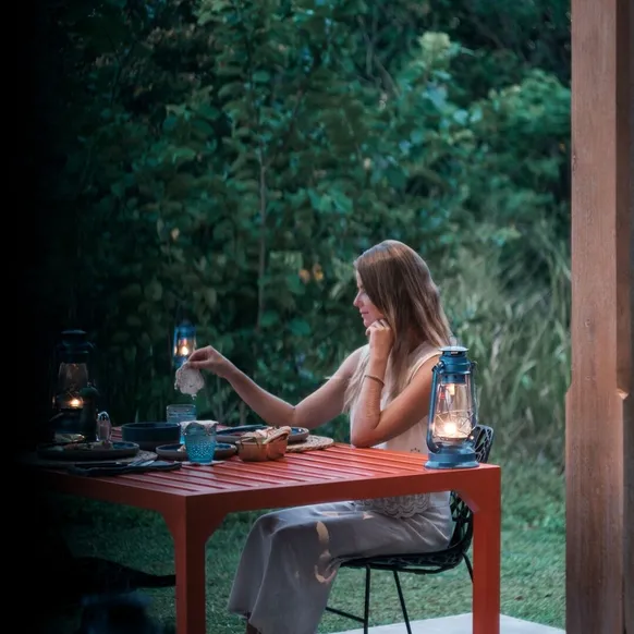 A guest at the garden table with lanterns as the light goes at Peacock Hill Sigiriya