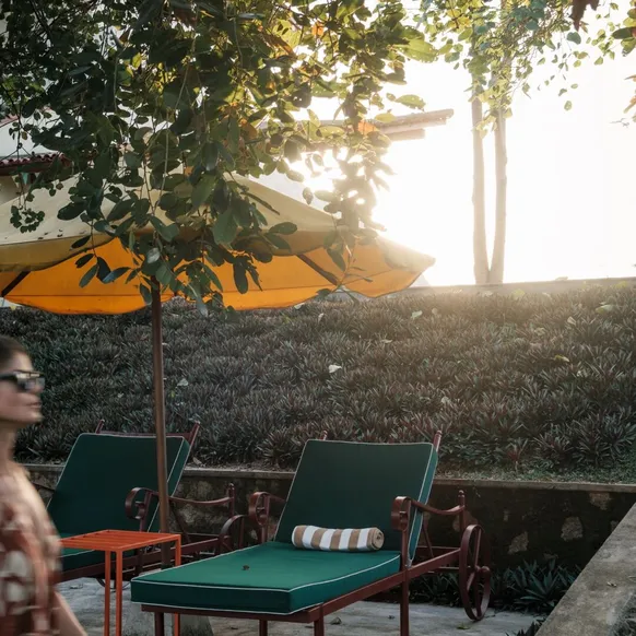 Loungers and parasols on the lawn in late afternoon light at Peacock Hill Sigiriya