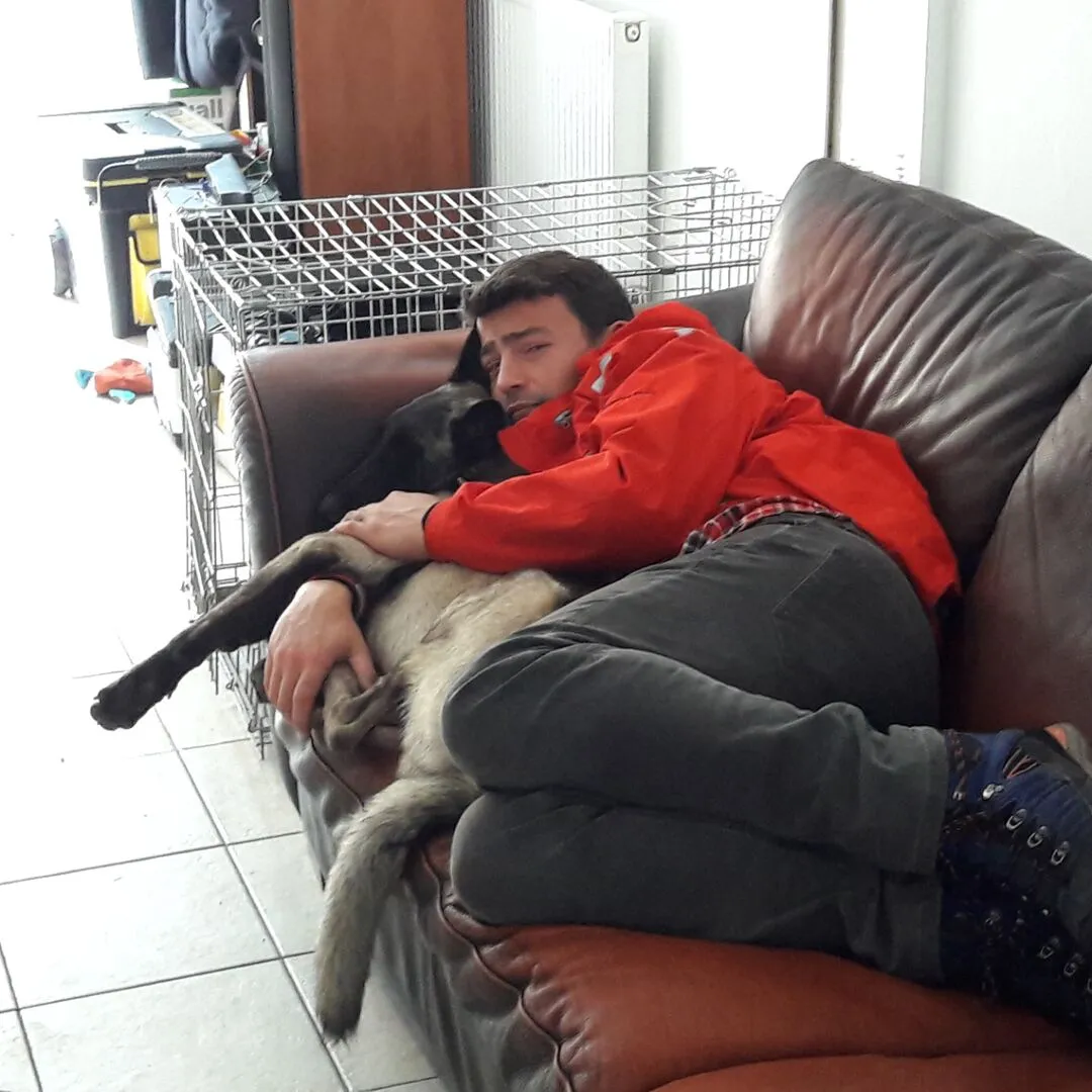Chris Brooks and his dog relaxing together on the sofa