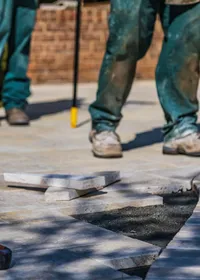Landscapers laying stone paving for a garden patio