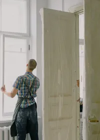 Handyman in an apron fitting a window during a renovation