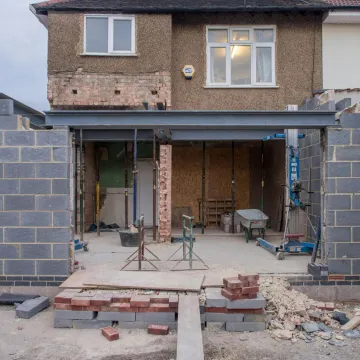 Brick house under renovation with an extension in