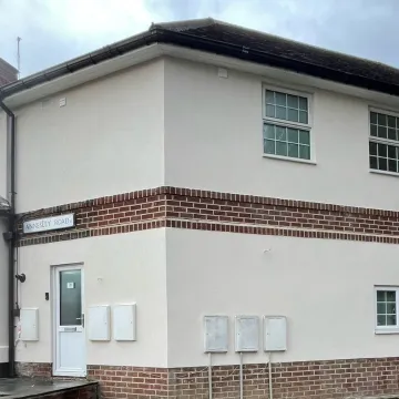 White house render with red brick surround