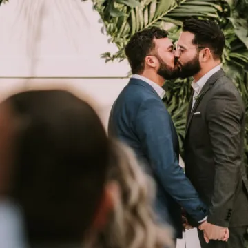 men-wearing-suit-kissing-in-front-of-people-3491999