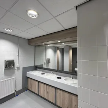 Refurbished washroom at QBE Leeds with mirrors and basins.