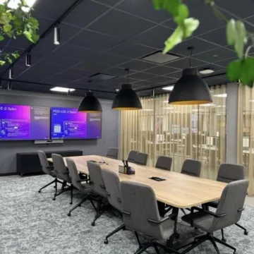 A Manchester company meeting room with computer screen displays on the wall.