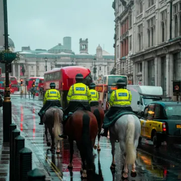 Back View of Police Officers on Horseback on a Busy Street in London, England, UK