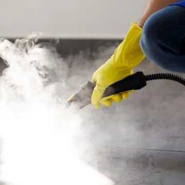 Professional cleaning service person using steam