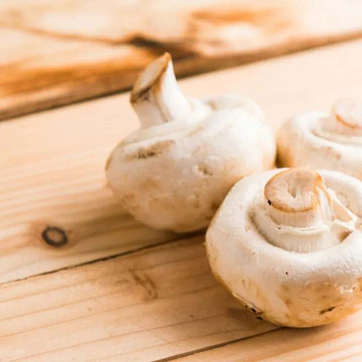Fresh white mushrooms on a wooden table
